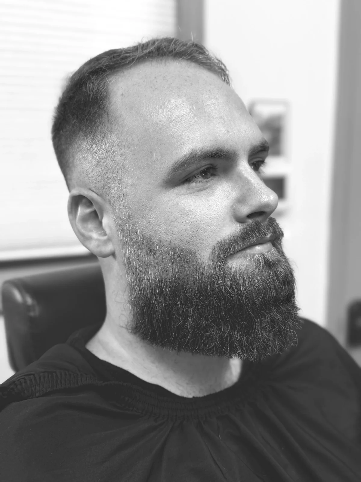 Short side-part haircut and full sculpted beard at PLATA